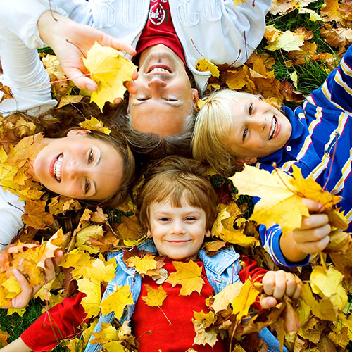 Familie mit 2 Kindern liebt im Laub